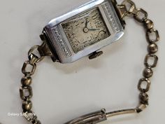 A vintage lady's Elgin wristwatch from the late 1930s to early 1940s. Features a white gold over sterling bracelet with adjustable clasp. Delicate and charming, with cast details and Art Deco styling to the steel case.  This watch has not been cleaned or repaired, and is untested. The enamel of the watch face is worn and fading, and back of the case is scratched and discolored.  A note about size: the bracelet is quite small, and I couldn't fit it over my hand to try it on my 6" wrist. Sterling Bracelets, Watch Faces, Women Wrist Watch, Sterling Silver Bracelet, Art Deco Design, Style Art, Sterling Silver Bracelets, Austria, Favorite Jewelry