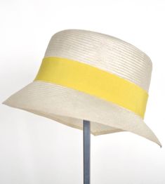 "\"Kami\" is pure elegance. The handmade hat is available in the high-quality \"parasisol\" with a lemmon yellow coloured hatband. Available in sizes 55 cm - 58 cm. Colour \"natur\" with a lemmon yellow coloured hatband and black accent Parasol hat (plaited straw) 66% cotton and 34% polyamide on the inside Ribbon of cotton and viscose Handmade Individualization options Other colours or sizes on request. All hats are handmade. For the production of a perfect hat it takes some time. All hats are r Chic Cream Toquilla Straw Boater Hat, Beige Toquilla Straw Bucket Hat With Flat Brim, Elegant Straw Sun Hat With Curved Brim, Brimmed Beige Toquilla Straw Bucket Hat, Elegant Natural Straw Hat With Flat Brim, Elegant Natural Color Straw Hat With Flat Brim, Cream Flat Brim Sun Hat In Toquilla Straw, Cream Boater Hat With Short Brim In Toquilla Straw, Spring Cream Boater Hat In Toquilla Straw