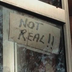 a sign that says not real on the side of a window