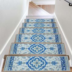 a set of stairs with blue and white carpet on the bottom, leading up to an open door