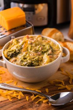 a casserole dish with cheese and broccoli in it on a cutting board