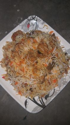 a white plate topped with rice and meat