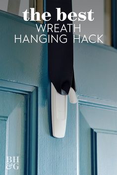 the door handle is hanging on the blue wall and it says, the best wreath hanging hack