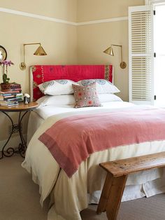 an article in the magazine shows a bedroom with pink and white bedding, pillows, and