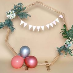 balloons and garlands are arranged on the wall for a wedding photo shoot in front of a hexagonal backdrop