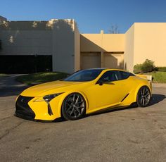 a yellow sports car parked in front of a building