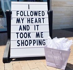 a shopping bag sitting next to a sign that says i followed my heart and it took me shopping