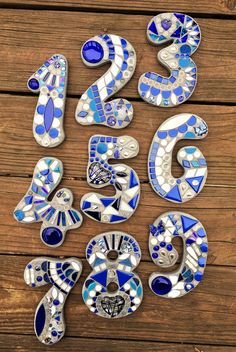 blue and white glass numbers sitting on top of a wooden table