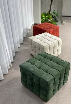 three different colored ottomans sitting on the floor