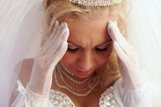 a woman wearing white gloves holding her hands to her head