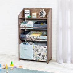 a book shelf with several storage bins on top of it in a child's room