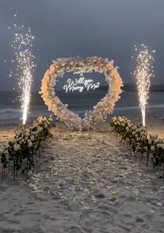 the wedding arch is decorated with white flowers and sparklers in the shape of a heart