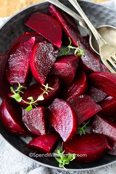 a bowl filled with sliced up beets next to a fork