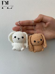 two small crocheted animals are being held by someone's hand