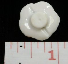 a white ceramic flower with a measuring tape