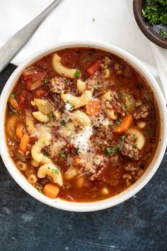 a white bowl filled with pasta and meat soup