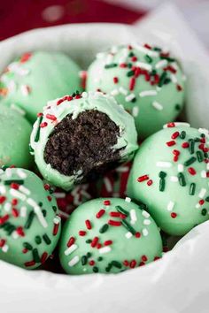 green cake truffles with white and red sprinkles in a bowl