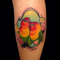 a couple of birds sitting on top of each other's legs with flowers around them