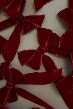 red bows are scattered on a white surface with no one in the photo looking at them