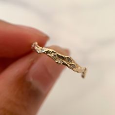 a tiny gold ring that is in someone's hand