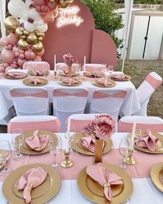 a table set up for a party with pink and gold plates, napkins, flowers and balloons