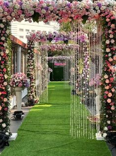 an outdoor wedding ceremony with pink and white flowers on the grass, hanging from the ceiling