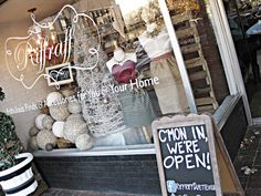 the front window of a clothing store with mannequins and other items on display