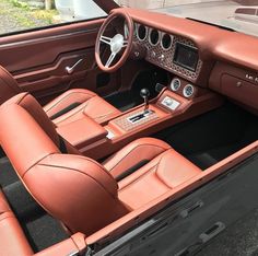 the interior of an old car with leather seats and dashboards, including steering wheel controls