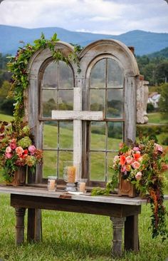 an old window is decorated with flowers and candles