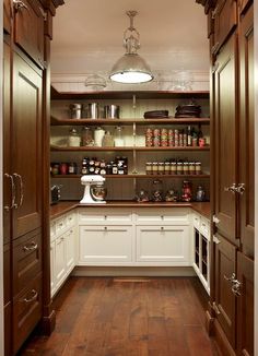 an open pantry with wooden floors and white cabinets