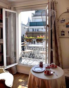 a room with a table, chairs and a window looking out onto the street outside