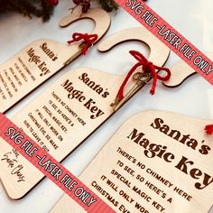 wooden key tags with red ribbon tied to them on a white table next to a christmas tree