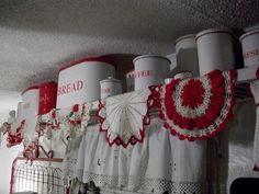 red and white crochet doily is hanging from the ceiling in this kitchen