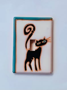 a decorative light switch cover with a cat on it