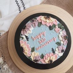 a birthday cake decorated with pink and blue flowers