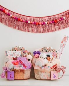 two baskets filled with lots of different items on top of a table next to a banner