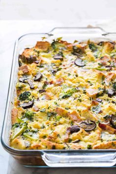 a casserole dish with broccoli, mushrooms and cheese in it on a table