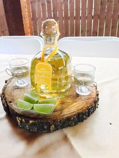 a bottle of lemonade sitting on top of a wooden table next to shot glasses