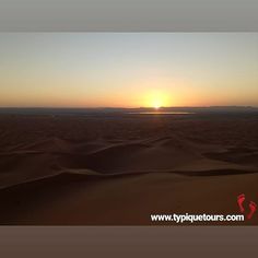 the sun is setting over sand dunes in the desert