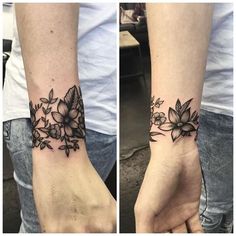 two hands with tattoos on them, one has flowers and the other has leaves in it