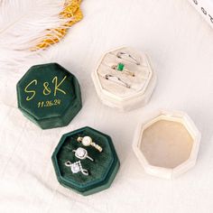 three ring boxes sitting on top of a white blanket