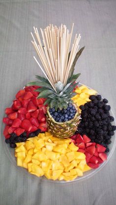 a fruit platter with strawberries, blueberries, raspberries and pineapples