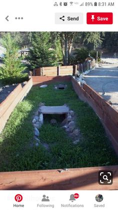 an open fire pit in the middle of a yard with rocks and grass around it