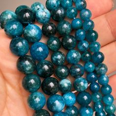 a hand holding several blue beads in it's palm