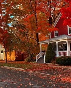 a red house surrounded by fall foliage and trees