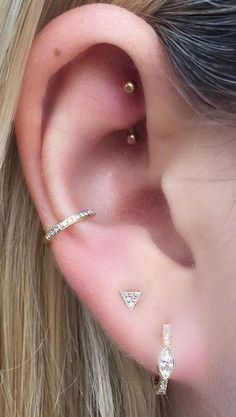 a close up of a person's ear with two different piercings on it