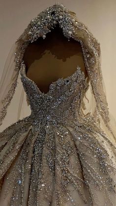 the back of a wedding dress with sequins and beading on display in a museum