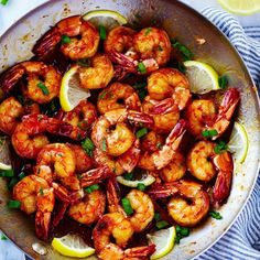 a pan filled with cooked shrimp and lemon slices