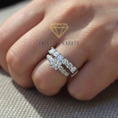 a woman's hand with a diamond ring on her left hand and two diamonds in the middle