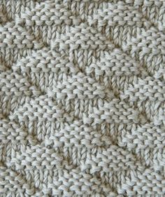 close up view of the crochet stitches on an afghan knitted with white yarn